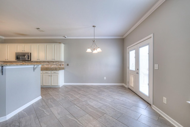 21 Cypress Hill Dr, Lebanon, TN 37087 - kitchen featuring stainless steel microwave, a chandelier, ornamental molding, white cabinetry, and light stone counters