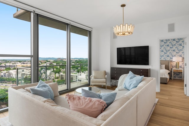 1212 Laurel St Unit 2005, Nashville, TN 37203 - living area with a wall of windows, plenty of natural light, a chandelier, light wood finished floors, and a view of city