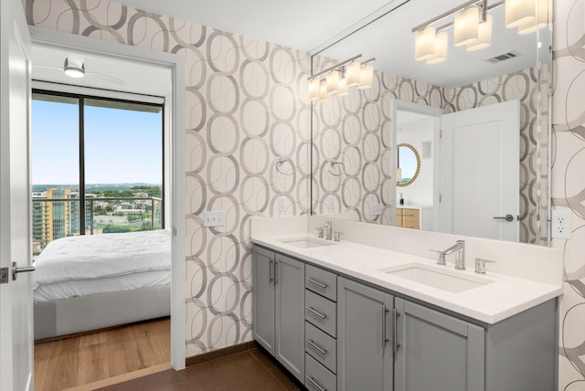 1212 Laurel St Unit 2005, Nashville, TN 37203 - ensuite bathroom featuring wallpapered walls, double vanity, baseboards, and wood finished floors