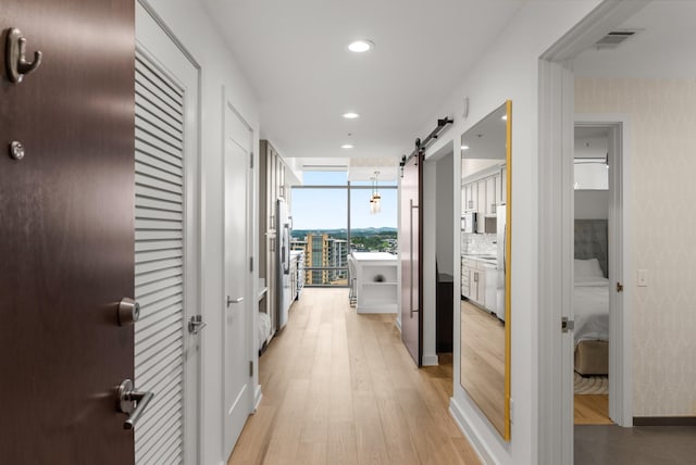 1212 Laurel St Unit 2005, Nashville, TN 37203 - corridor featuring light wood finished floors, expansive windows, recessed lighting, a barn door, and baseboards