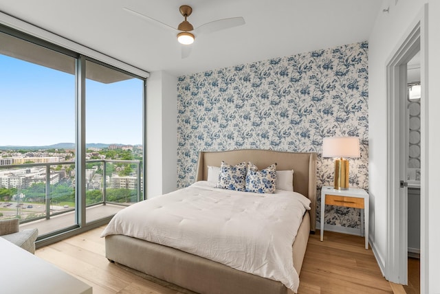 1212 Laurel St Unit 2005, Nashville, TN 37203 - bedroom with wallpapered walls, wood finished floors, access to outside, floor to ceiling windows, and baseboards