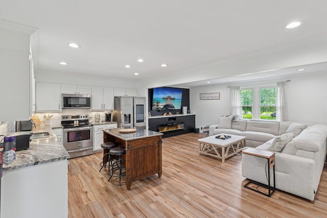 1006 Indian Trl, Castalian Springs, TN 37031 - living area featuring ornamental molding, recessed lighting, light wood-style flooring, and a glass covered fireplace