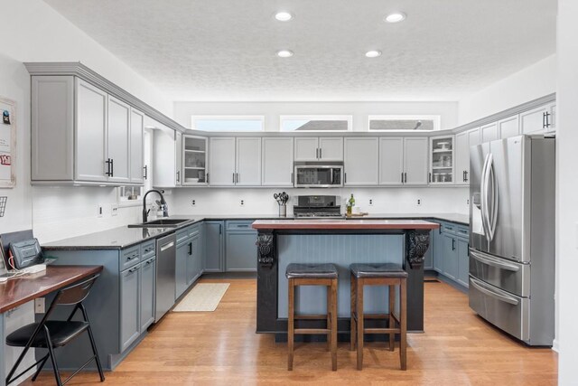 1300 Wentworth Dr, Gallatin, TN 37066 - kitchen with stainless steel appliances, a sink, a breakfast bar area, a kitchen island, and glass insert cabinets