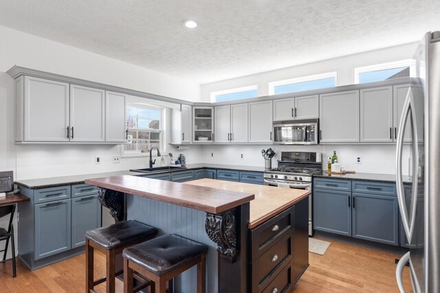 1300 Wentworth Dr, Gallatin, TN 37066 - kitchen featuring stainless steel appliances, butcher block countertops, a sink, a breakfast bar area, and light wood-style flooring