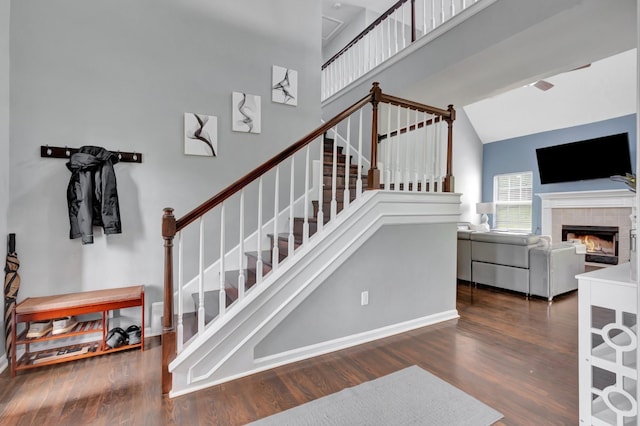 1838 Oreilly Cir, Spring Hill, TN 37174 - stairway featuring a high ceiling, wood finished floors, a tile fireplace, ceiling fan, and baseboards