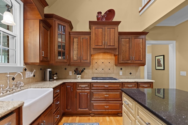 15687 Columbia Hwy, Lynnville, TN 38472 - kitchen with a sink, light stone countertops, light wood finished floors, stainless steel gas cooktop, and glass insert cabinets