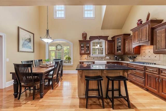 15687 Columbia Hwy, Lynnville, TN 38472 - kitchen with a high ceiling, stainless steel gas cooktop, light wood-style floors, glass insert cabinets, and plenty of natural light