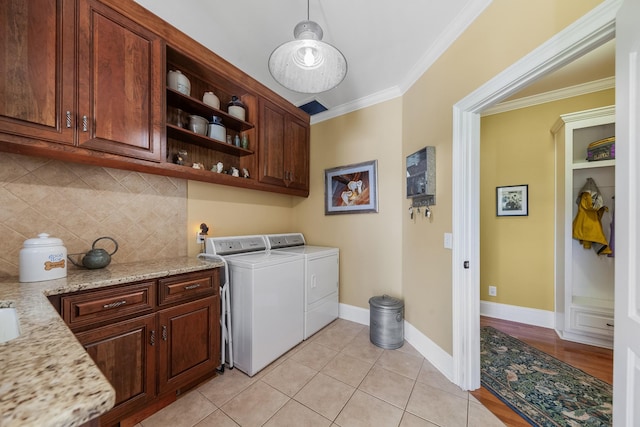 15687 Columbia Hwy, Lynnville, TN 38472 - laundry area featuring separate washer and dryer, crown molding, cabinet space, light tile patterned floors, and baseboards