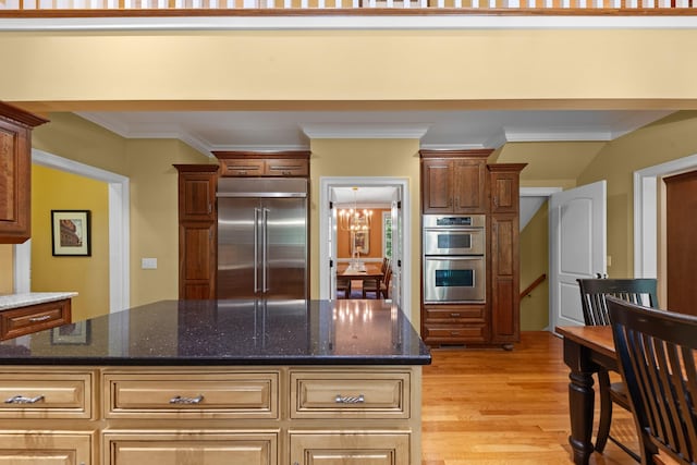 15687 Columbia Hwy, Lynnville, TN 38472 - kitchen featuring stainless steel appliances, light wood-style floors, ornamental molding, dark stone counters, and a center island