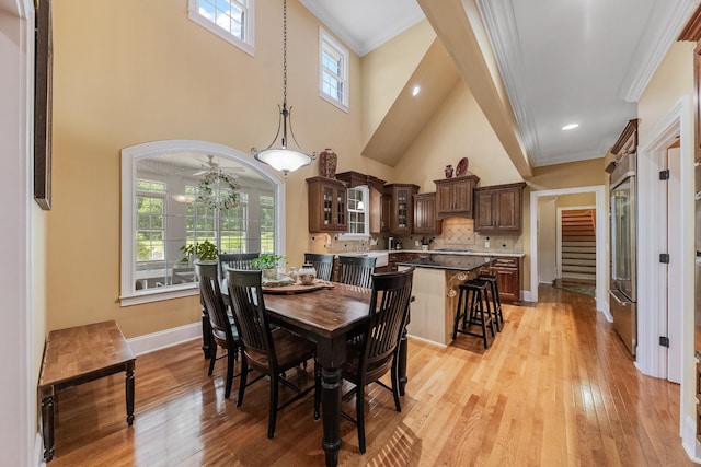 15687 Columbia Hwy, Lynnville, TN 38472 - dining space featuring crown molding, light wood-style flooring, a high ceiling, a chandelier, and baseboards
