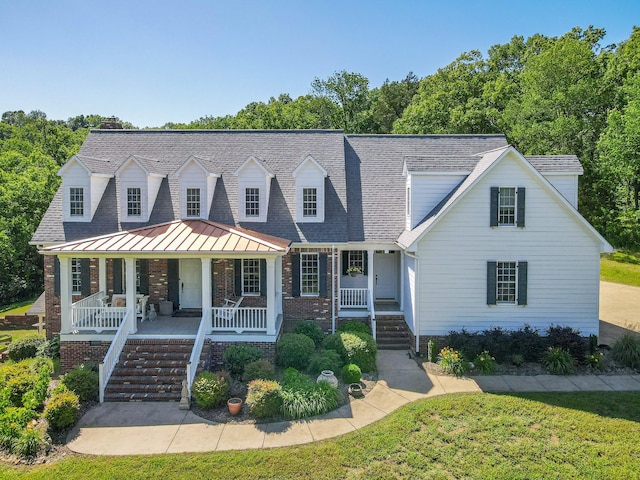 15687 Columbia Hwy, Lynnville, TN 38472 - new england style home with covered porch, brick siding, stairway, and a front yard