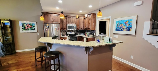 222 Pumphill Rd, Dickson, TN 37055 - kitchen featuring stainless steel appliances, dark wood finished floors, a breakfast bar, tasteful backsplash, and baseboards