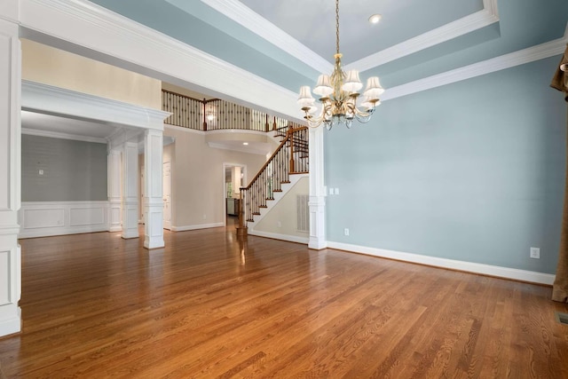 3037 Flagstone Dr, Franklin, TN 37069 - spare room with stairs, ornamental molding, wood finished floors, ornate columns, and a chandelier