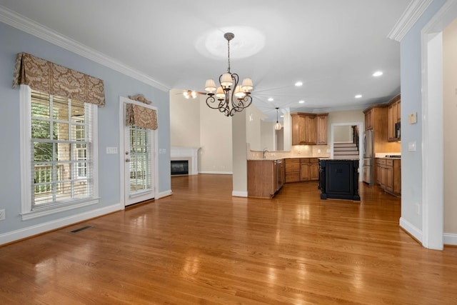 3037 Flagstone Dr, Franklin, TN 37069 - kitchen with freestanding refrigerator, crown molding, open floor plan, brown cabinets, and a chandelier