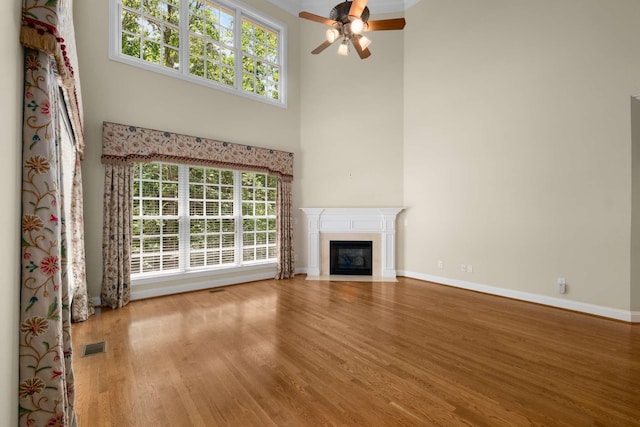 3037 Flagstone Dr, Franklin, TN 37069 - unfurnished living room with ceiling fan, wood finished floors, baseboards, a fireplace with flush hearth, and a towering ceiling
