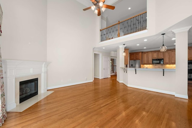 3037 Flagstone Dr, Franklin, TN 37069 - unfurnished living room with ceiling fan, light wood-type flooring, a towering ceiling, a fireplace with flush hearth, and recessed lighting