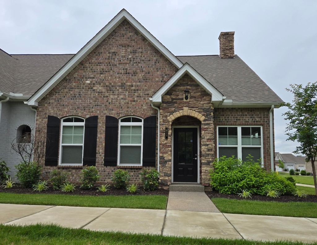 312 Buckner Cir, Mount Juliet, TN 37122 - view of front of home with roof with shingles, a chimney, brick siding, and stone siding