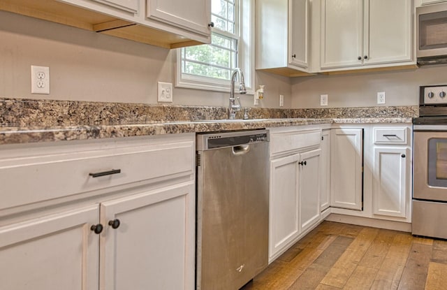 143 Rachelle Pl, Baxter, TN 38544 - kitchen featuring appliances with stainless steel finishes, white cabinetry, light wood-type flooring, and a sink