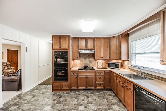 435 Richland Cir, Gallatin, TN 37066 - kitchen with black appliances, under cabinet range hood, brown cabinets, backsplash, and stone finish flooring