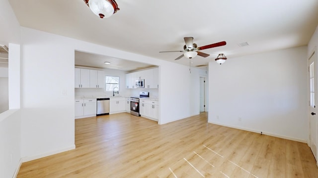 121 Highland St, La Vergne, TN 37086 - unfurnished living room featuring a sink, light wood finished floors, ceiling fan, and baseboards