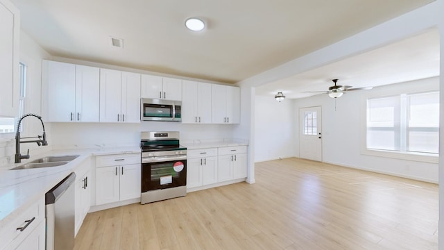 121 Highland St, La Vergne, TN 37086 - kitchen with stainless steel appliances, a sink, light wood-style floors, light stone counters, and white cabinets