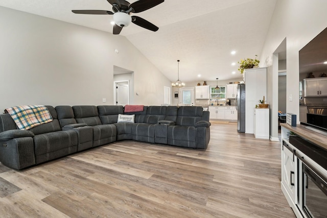 125 Vivian Ln, Carthage, TN 37030 - living room with lofted ceiling, ceiling fan, light wood-style floors, and a chandelier