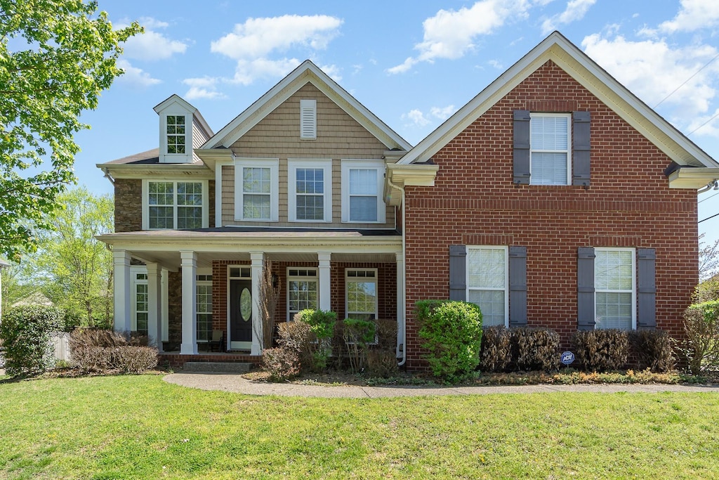 1033 Wyntergrace Farm Rd, Old Hickory, TN 37138 - view of front of house with covered porch, a front yard, and brick siding