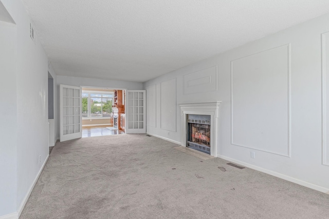 108 Agee Cir W, Hendersonville, TN 37075 - unfurnished living room featuring a fireplace with flush hearth, carpet floors, baseboards, a textured ceiling, and french doors