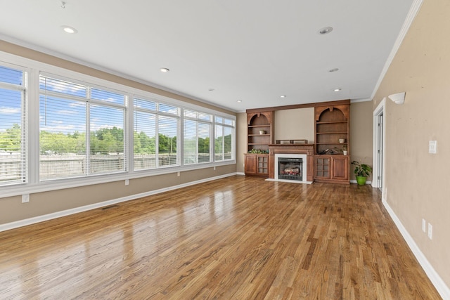 108 Agee Cir W, Hendersonville, TN 37075 - unfurnished living room featuring baseboards, wood finished floors, built in shelves, crown molding, and a fireplace