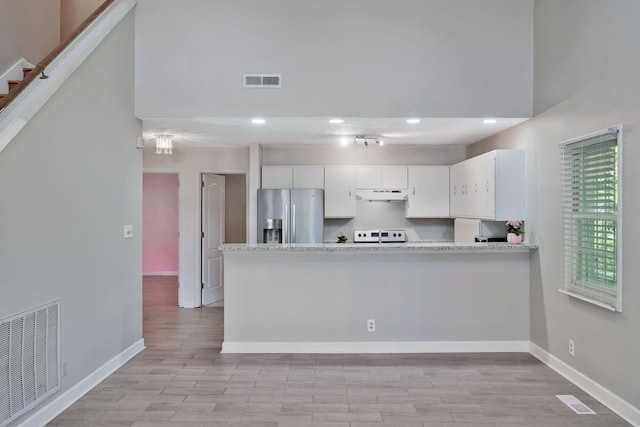 4905 Algonquin Trl, Antioch, TN 37013 - kitchen featuring stainless steel fridge, under cabinet range hood, white cabinets, light countertops, and light wood-type flooring