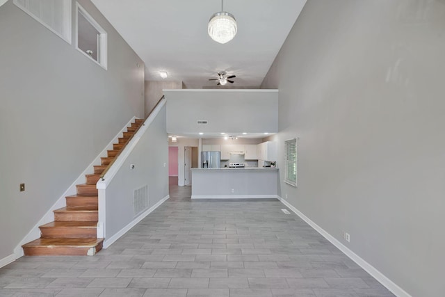 4905 Algonquin Trl, Antioch, TN 37013 - unfurnished living room featuring a ceiling fan, a high ceiling, baseboards, and stairs