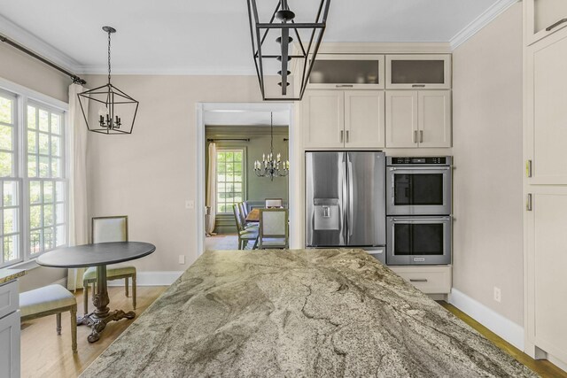1422 Primrose Ln, Franklin, TN 37064 - kitchen featuring a chandelier, appliances with stainless steel finishes, crown molding, light stone countertops, and glass insert cabinets