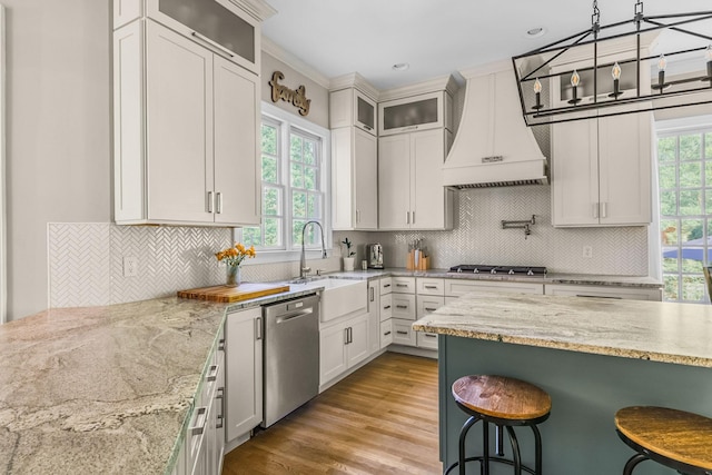 1422 Primrose Ln, Franklin, TN 37064 - kitchen with stainless steel appliances, premium range hood, a sink, a breakfast bar area, and light stone countertops