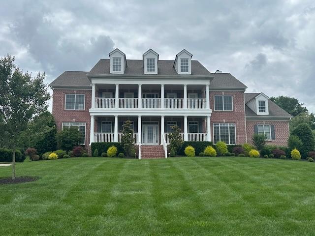 9166 Sydney Ln, Brentwood, TN 37027 - view of front facade featuring brick siding, a balcony, a front lawn, and covered porch