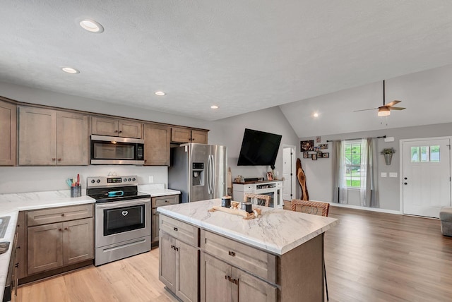 241 Holly Grove Rd, Lewisburg, TN 37091 - kitchen with appliances with stainless steel finishes, light wood finished floors, lofted ceiling, open floor plan, and a kitchen island
