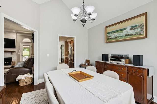 2754 Douglas Ln, Thompsons Station, TN 37179 - dining room featuring a chandelier, dark wood-type flooring, a brick fireplace, high vaulted ceiling, and baseboards