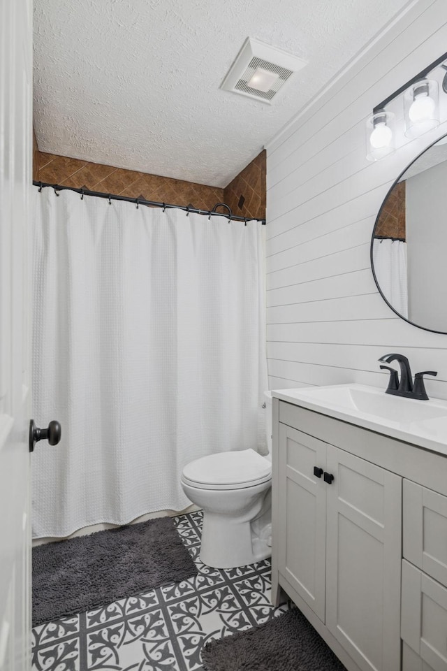 2754 Douglas Ln, Thompsons Station, TN 37179 - full bath featuring a textured ceiling, toilet, vanity, tile patterned floors, and wooden walls