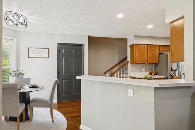 2754 Douglas Ln, Thompsons Station, TN 37179 - kitchen with brown cabinetry, a textured ceiling, stainless steel fridge, dark wood-style floors, and light countertops