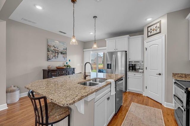 5190 Giardino Dr, Mount Juliet, TN 37122 - kitchen with a sink, appliances with stainless steel finishes, light wood-style flooring, white cabinets, and recessed lighting
