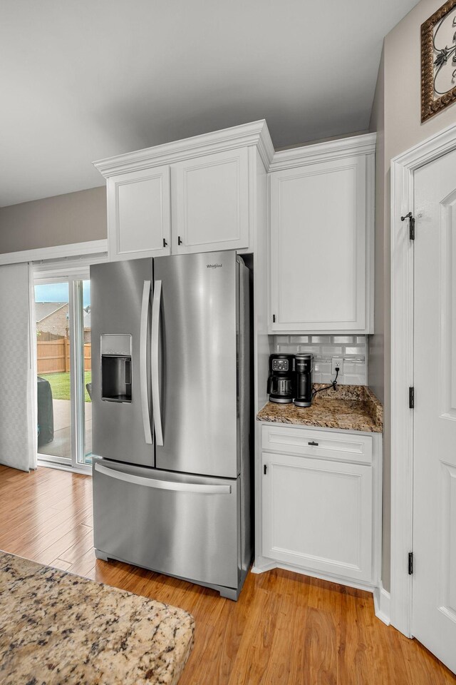 5190 Giardino Dr, Mount Juliet, TN 37122 - kitchen with stainless steel fridge with ice dispenser, white cabinetry, tasteful backsplash, light wood finished floors, and light stone counters