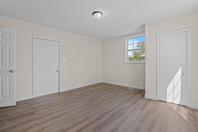 1601 S Willow St, Chattanooga, TN 37404 - unfurnished bedroom featuring wood finished floors, a textured ceiling, and baseboards