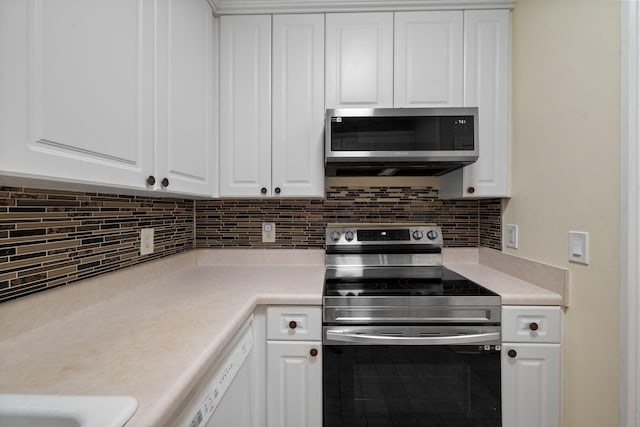 116 31st Ave N Unit 104, Nashville, TN 37203 - kitchen with stainless steel appliances, white cabinetry, light countertops, and backsplash
