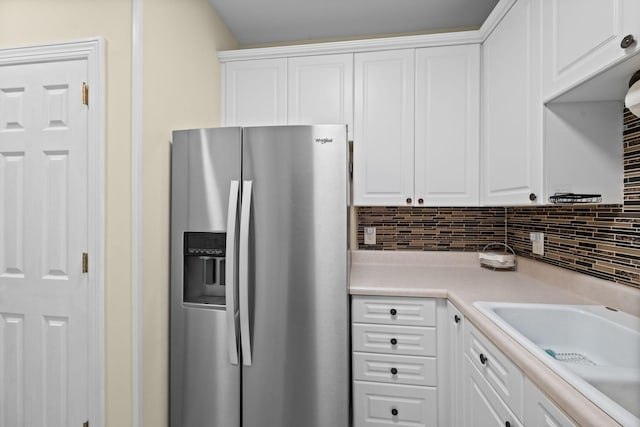 116 31st Ave N Unit 104, Nashville, TN 37203 - kitchen featuring stainless steel refrigerator with ice dispenser, white cabinets, light countertops, and backsplash