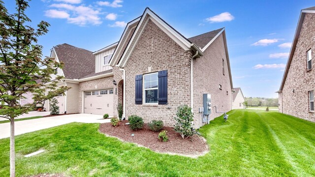 1137 Fiona Dr, Lebanon, TN 37087 - traditional home with concrete driveway, brick siding, a front lawn, board and batten siding, and an attached garage