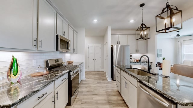 1137 Fiona Dr, Lebanon, TN 37087 - kitchen featuring appliances with stainless steel finishes, a sink, a center island with sink, dark stone counters, and recessed lighting