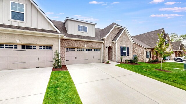 1137 Fiona Dr, Lebanon, TN 37087 - view of front of house with board and batten siding, brick siding, a front yard, driveway, and a shingled roof