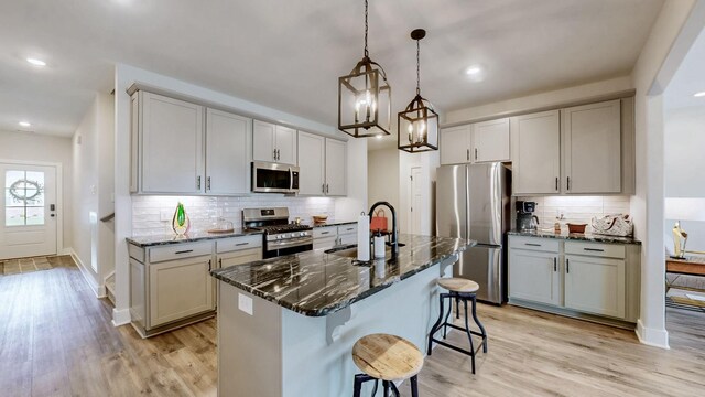 1137 Fiona Dr, Lebanon, TN 37087 - kitchen featuring stainless steel appliances, a sink, backsplash, dark stone countertops, and a kitchen breakfast bar