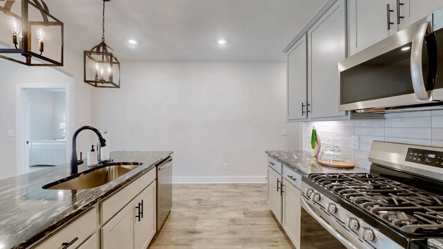 1137 Fiona Dr, Lebanon, TN 37087 - kitchen with appliances with stainless steel finishes, a sink, dark stone countertops, baseboards, and recessed lighting