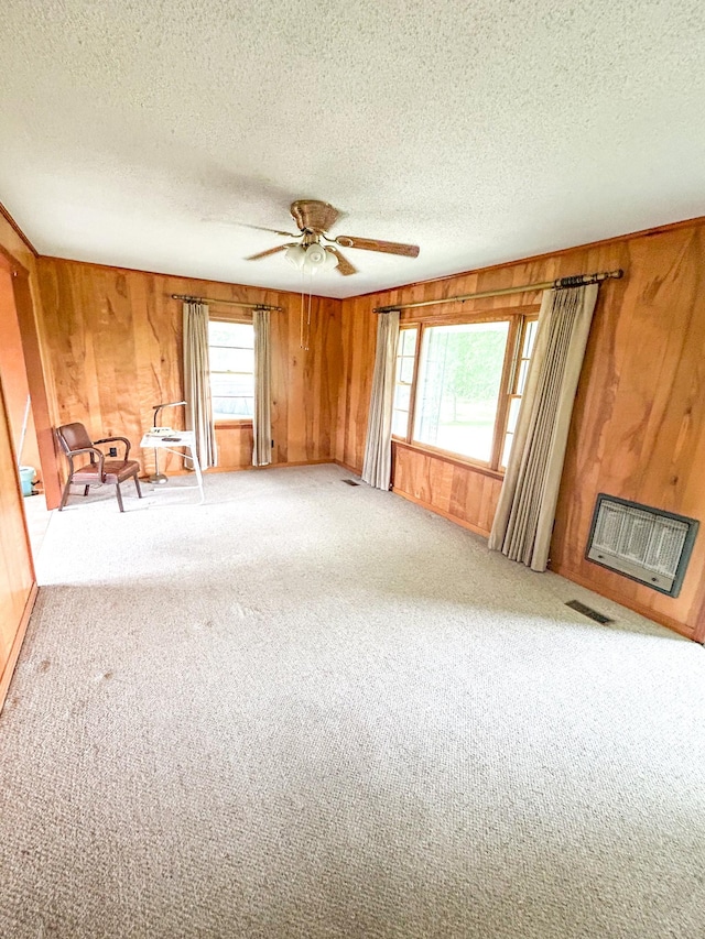 72 Allen Ln, Huntingdon, TN 38344 - unfurnished living room featuring wood walls, a textured ceiling, carpet flooring, and a ceiling fan