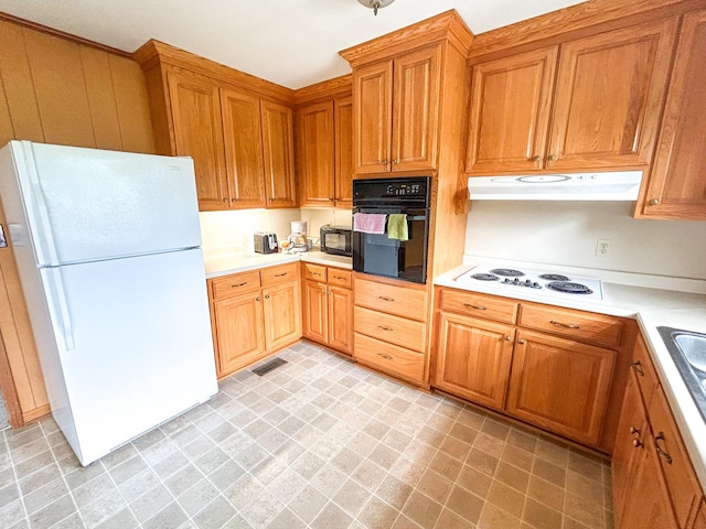 72 Allen Ln, Huntingdon, TN 38344 - kitchen with black appliances, under cabinet range hood, light countertops, light floors, and brown cabinets